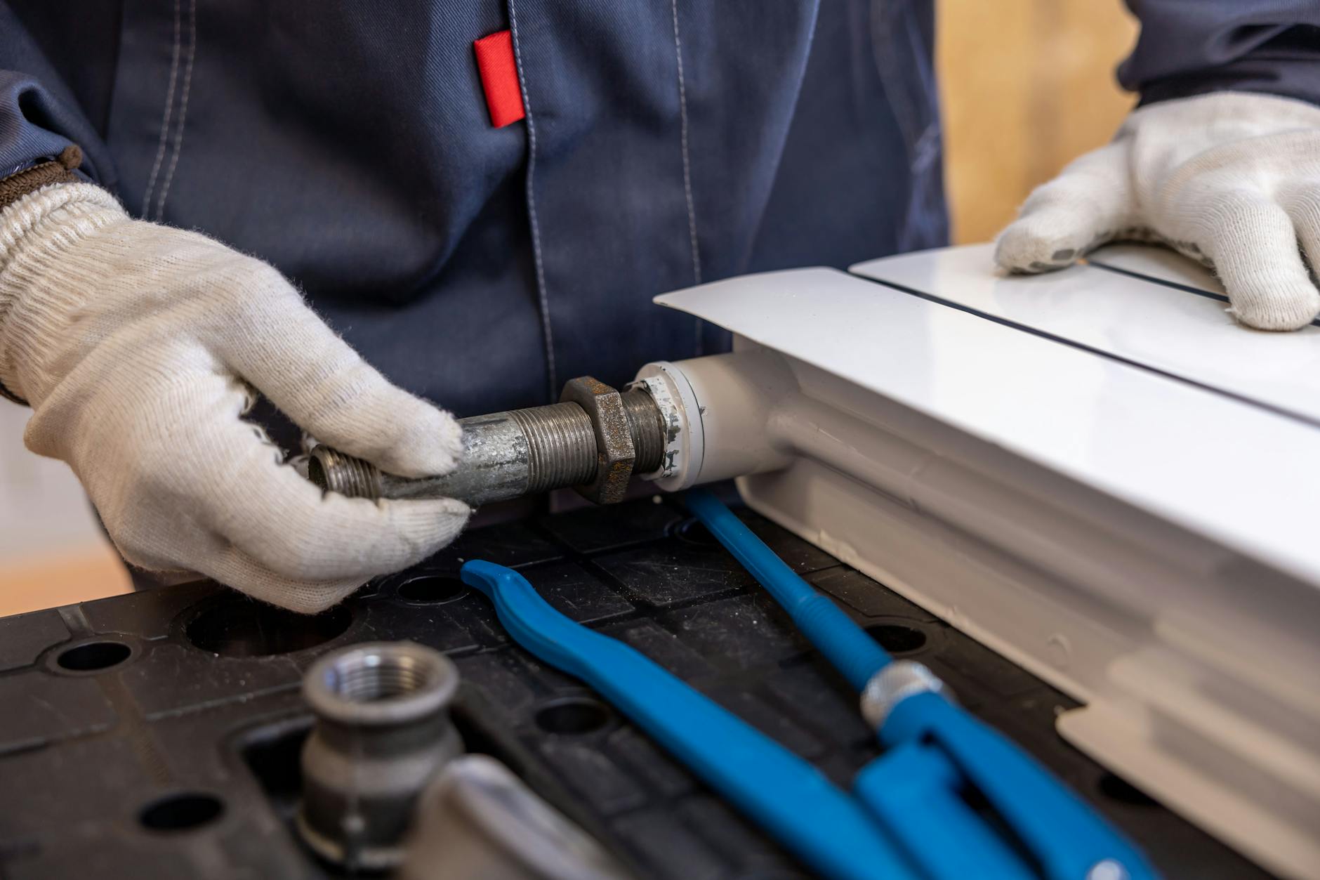 Plumber installing radiator pipe with precision